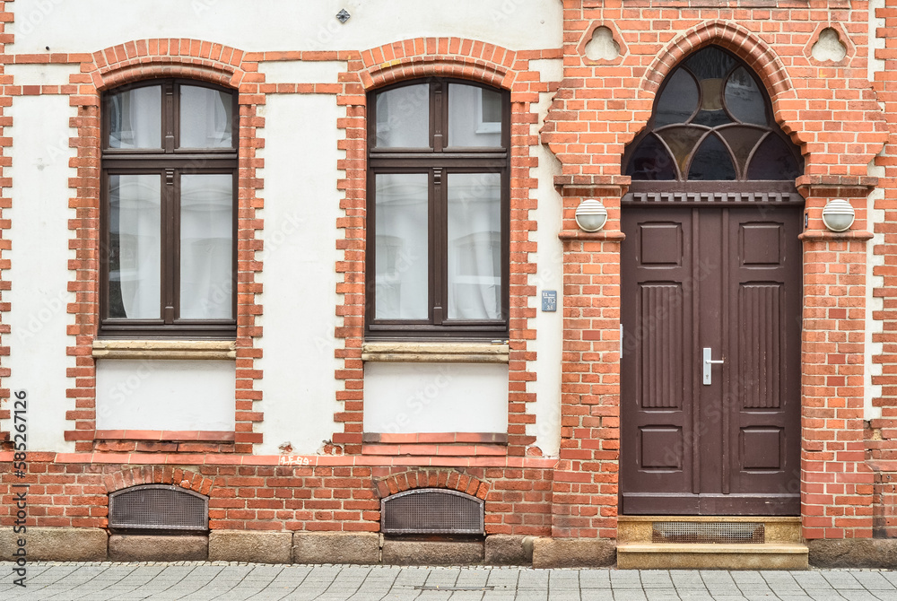 View of brick building with wooden door and windows