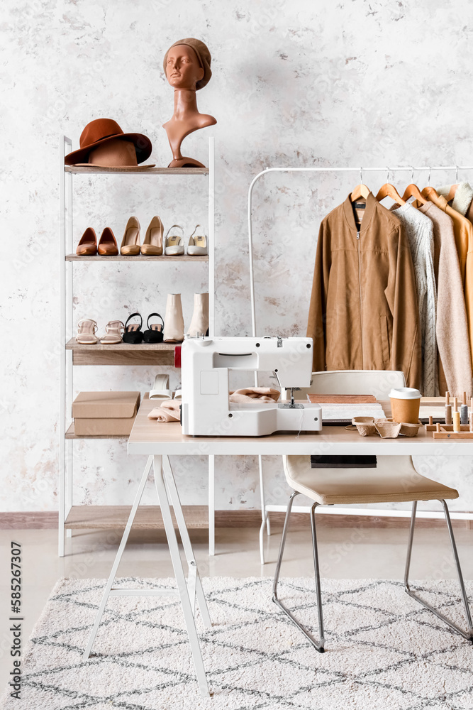 Interior of atelier with workplace, clothes and shelving unit