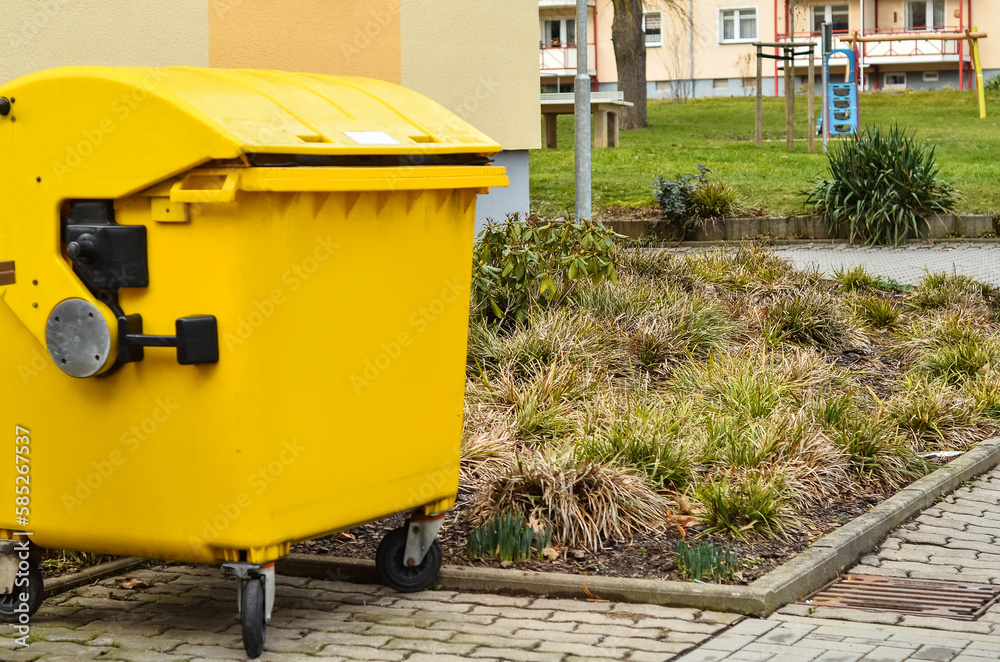 Yellow garbage container on city street