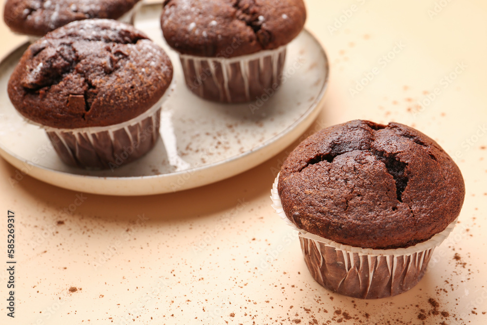 Tasty chocolate cupcakes on beige background