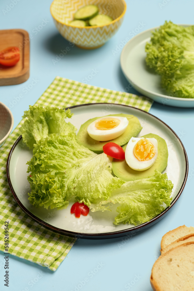 Plate with funny breakfast in shape of owl and ingredients on blue background, closeup