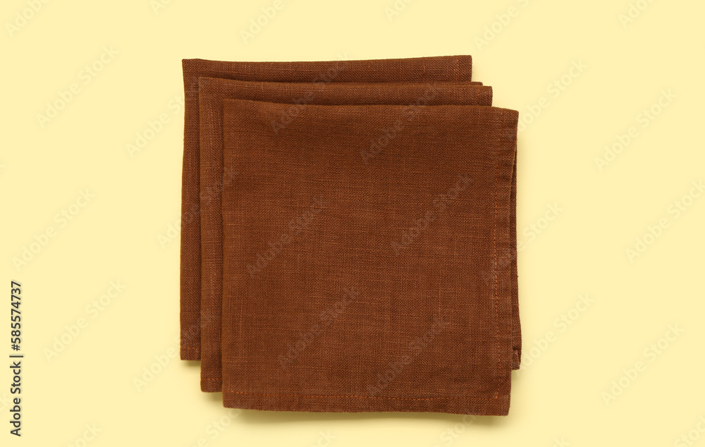 Folded napkins on yellow background