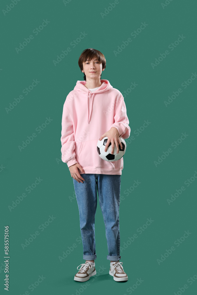 Teenage boy with soccer ball on green background