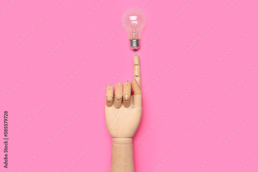 Wooden hand with light bulb on pink background. Insight concept