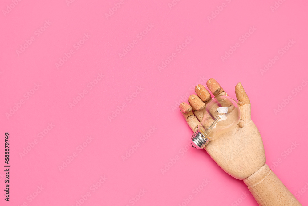 Wooden hand with light bulb on pink background. Insight concept