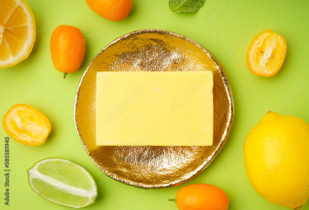 Composition with natural soap bar and citrus fruits on color background