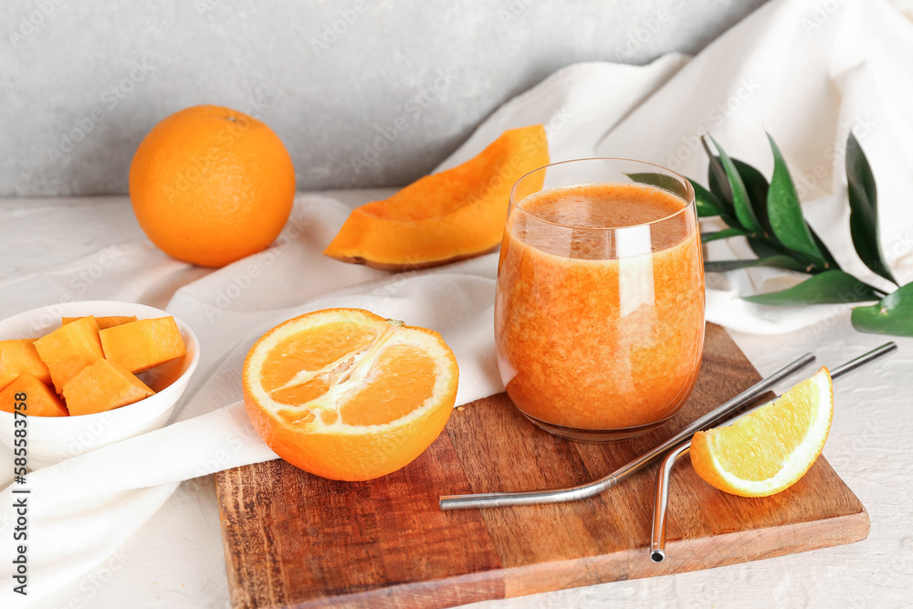 Glass of healthy smoothie and ingredients on light background