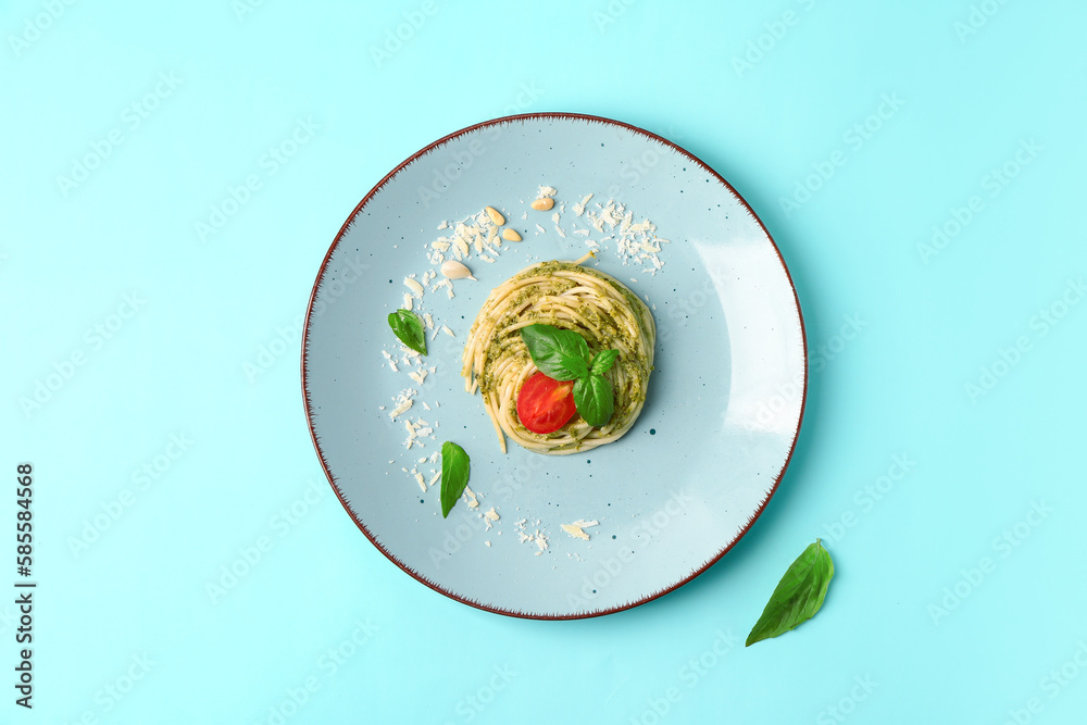 Plate with tasty pesto pasta on color background