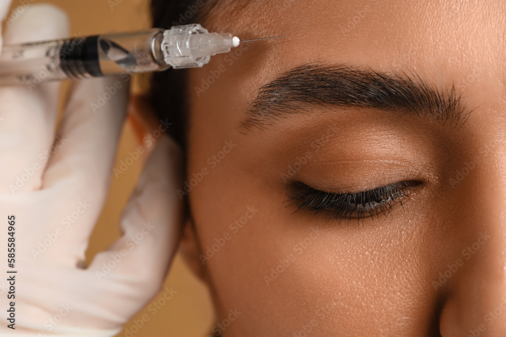 Young woman receiving filler injection in face, closeup