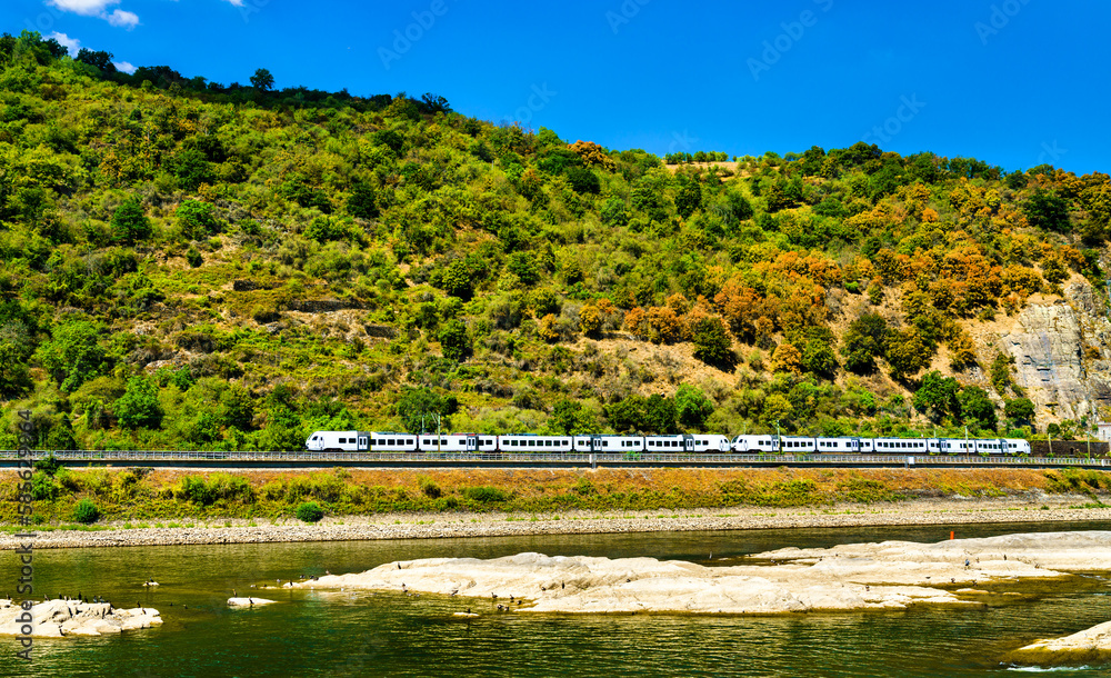 Passenger train at the Rhine River in the Rhine Gorge in Germany