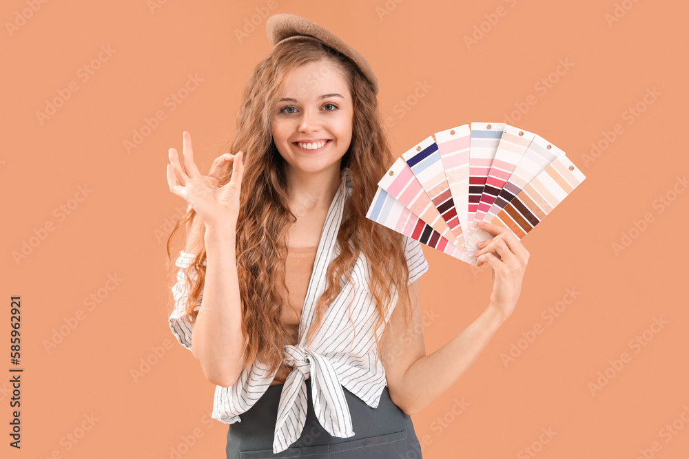 Female artist with paint color palettes showing OK on beige background