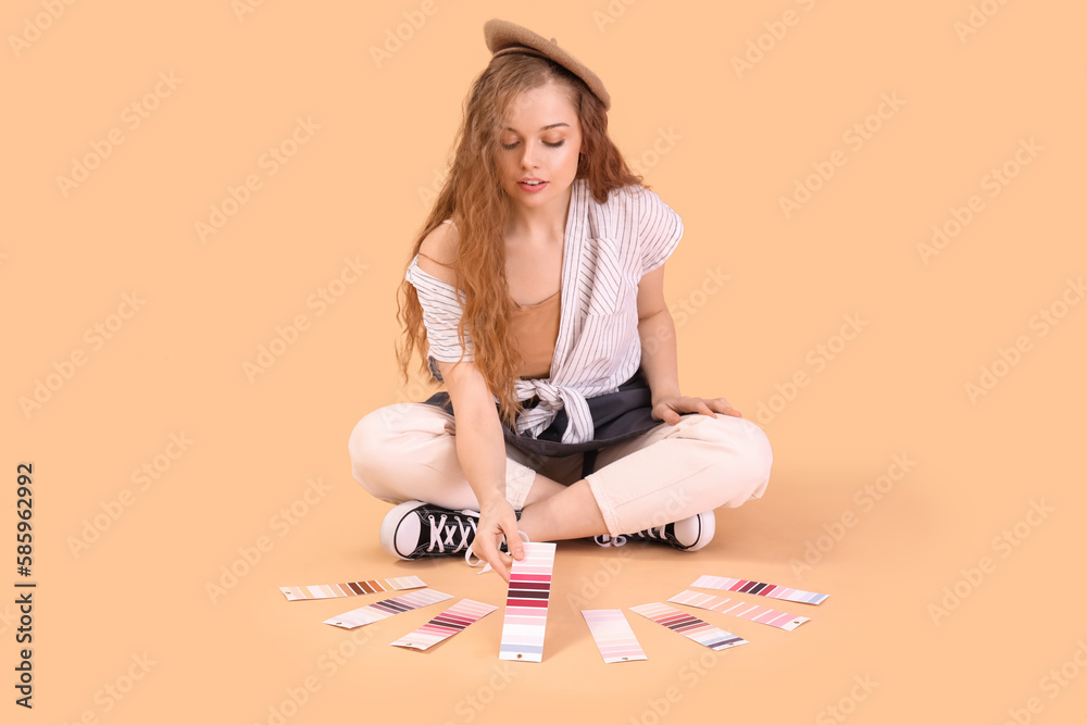 Female artist with paint color palettes sitting on beige background