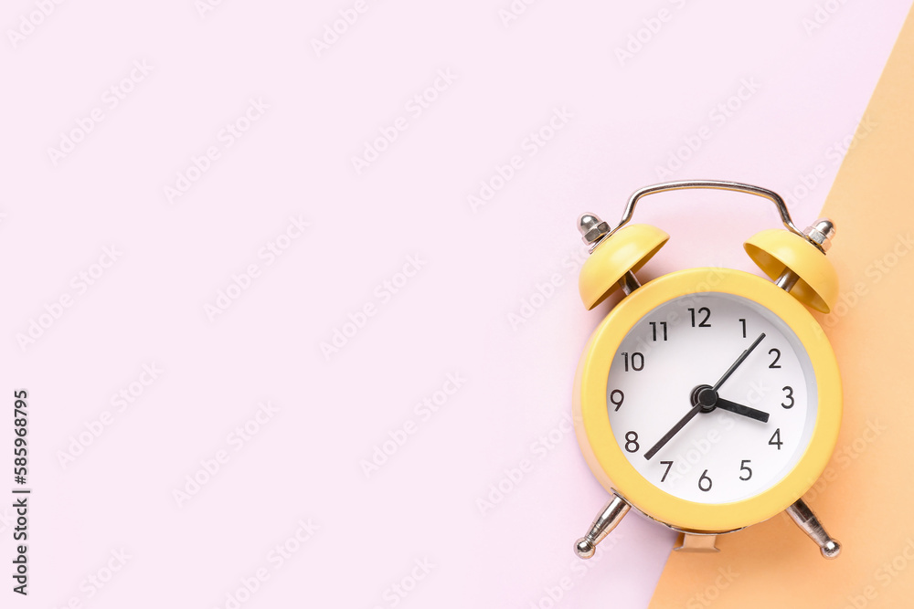 Vintage alarm clock on color background