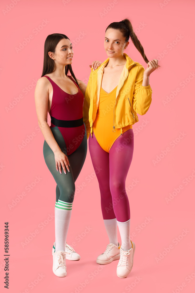 Portrait of sporty young women on pink background