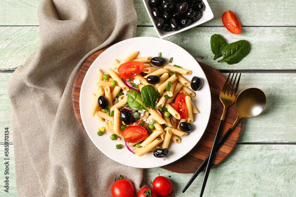 Plate with tasty pasta salad on light wooden background