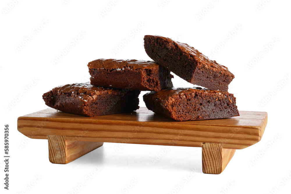 Wooden board with pieces of tasty chocolate brownie isolated on white background