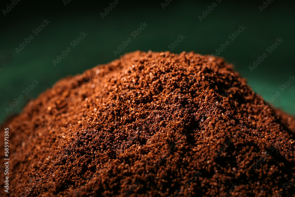 Heap of coffee powder on green background, closeup