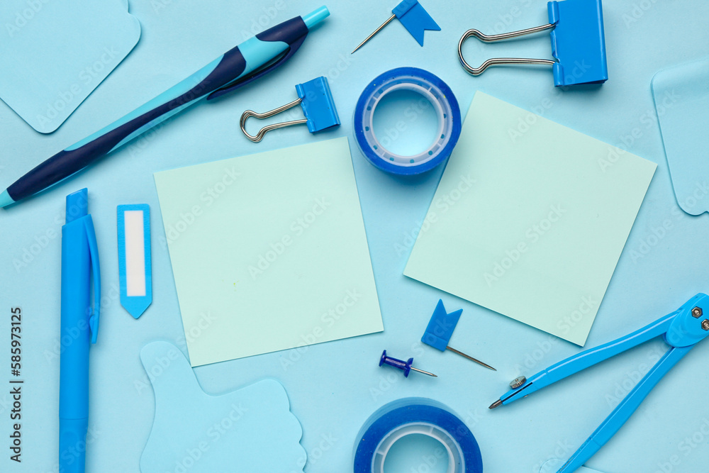 Composition with drawing compass, scotch tape and sticky notes on blue background