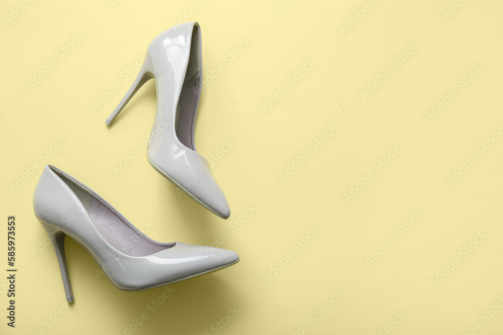 Stylish high heeled shoes on beige background