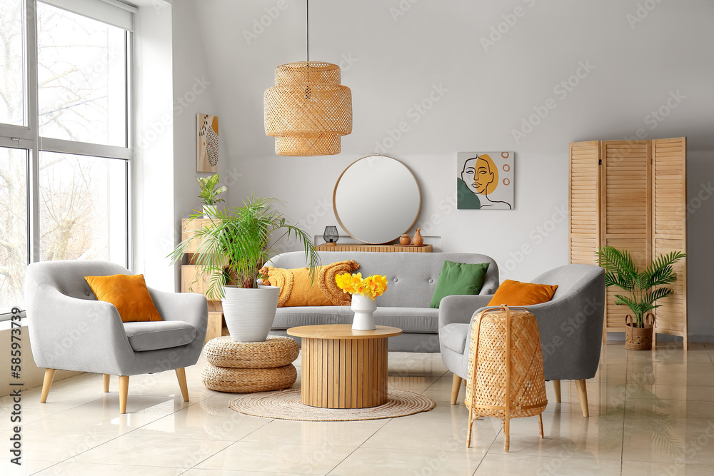 Interior of cozy living room with sofa, armchairs and flower vase on coffee table