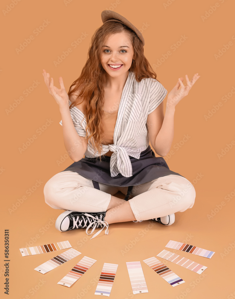 Female artist with paint color palettes sitting on beige background