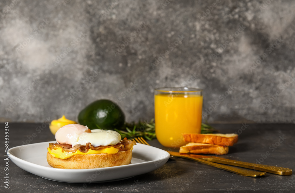 Plate with tasty egg Benedict and glass of orange juice on table