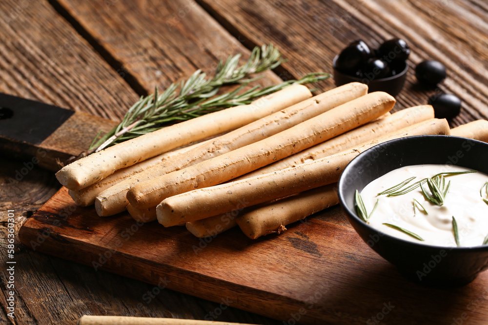 Board with tasty Italian Grissini on wooden background