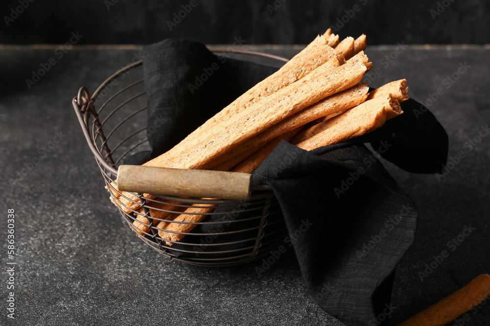 Basket with tasty Italian Grissini on dark background