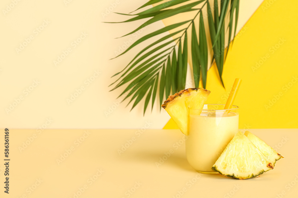 Glass of tasty pineapple smoothie and straw on color background