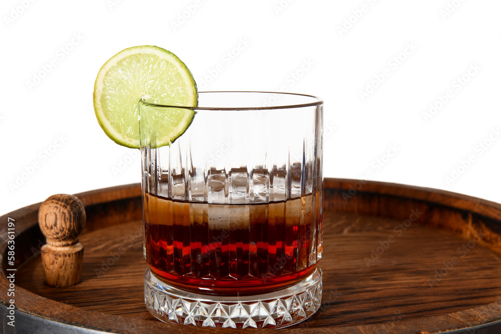 Glass of cold rum on wooden barrel against white background