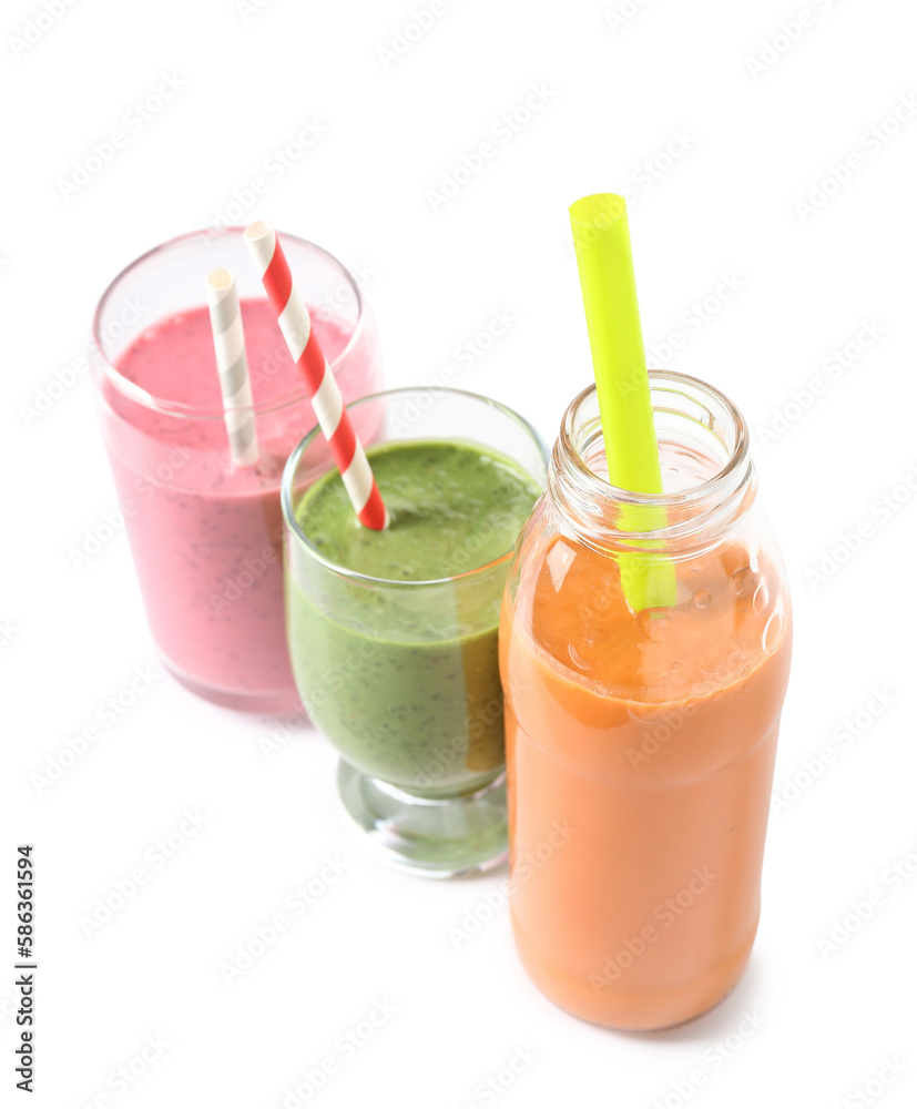 Glasses and bottle of different tasty smoothie with straws on white background