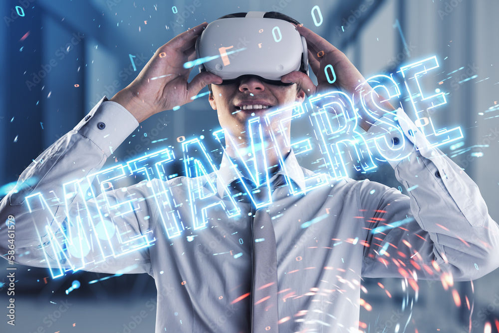 Cheerful young european businessman with VR glasses using glowing metaverse text hologram on blurry 