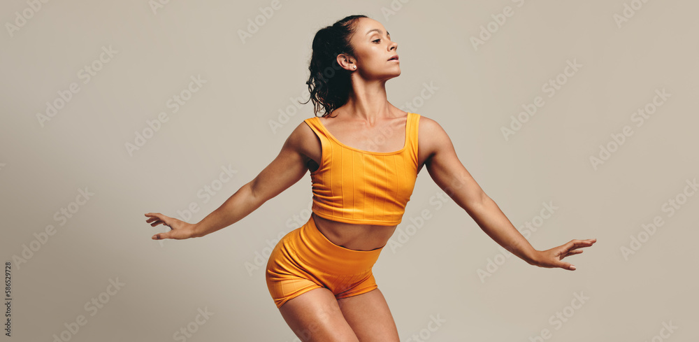 Gymnastic workout in the studio: Fit woman practicing her balance and flexibility