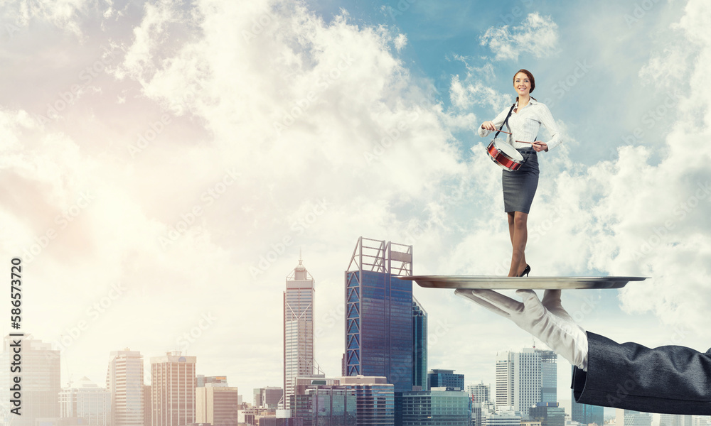 Attractive businesswoman on metal tray playing drums against cityscape background