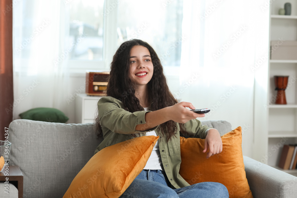 Teenage girl watching TV at home