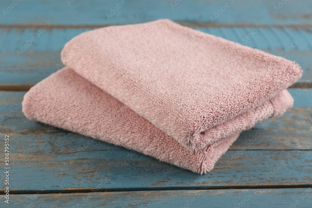 Folded soft towels on blue wooden background