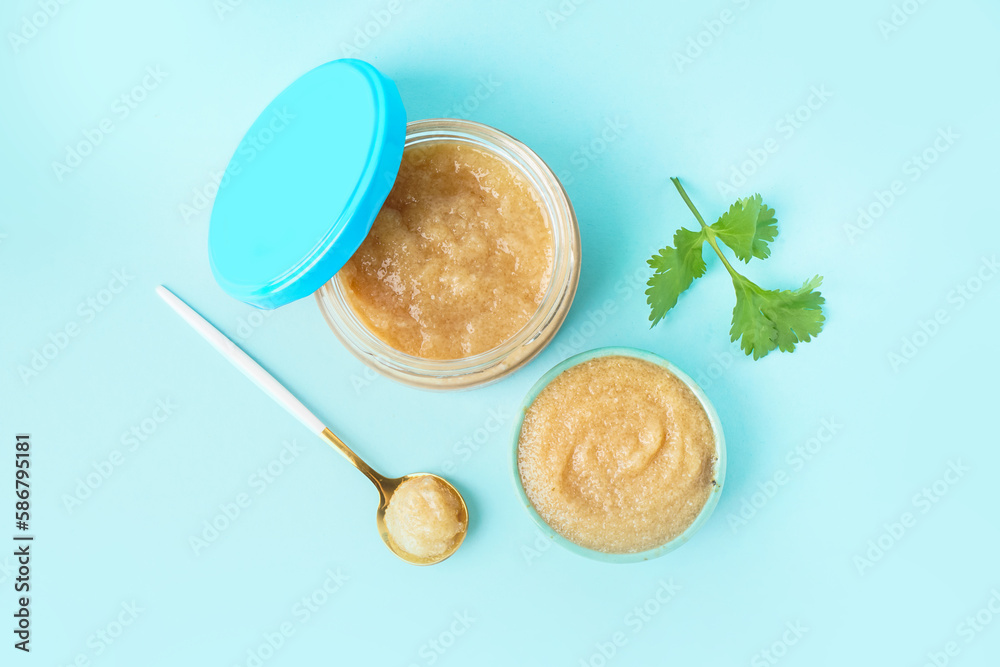 Bowl and jar with delicious caviar of capelin on blue background