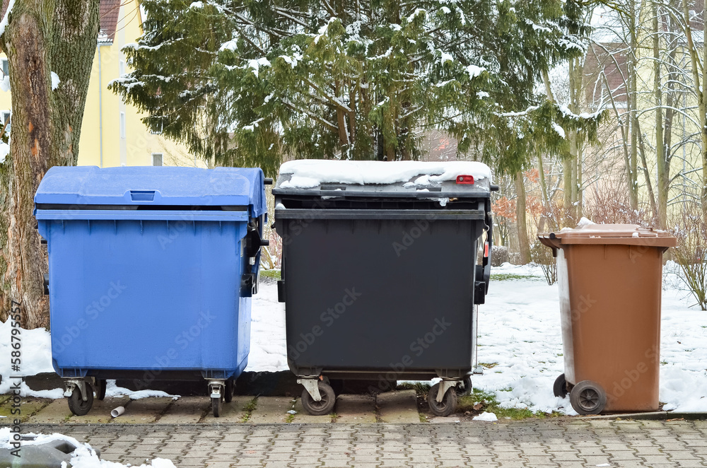 View of garbage containers in city on winter day