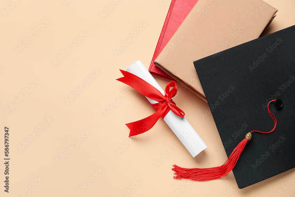 Diploma with red ribbon, graduation hat and books on beige background