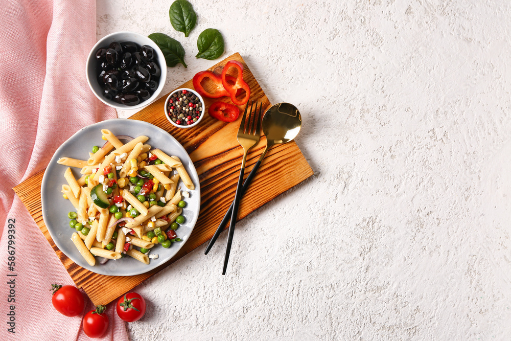 Plate with tasty pasta salad and ingredients on light background