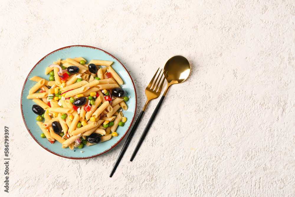 Plate with tasty pasta salad on light background