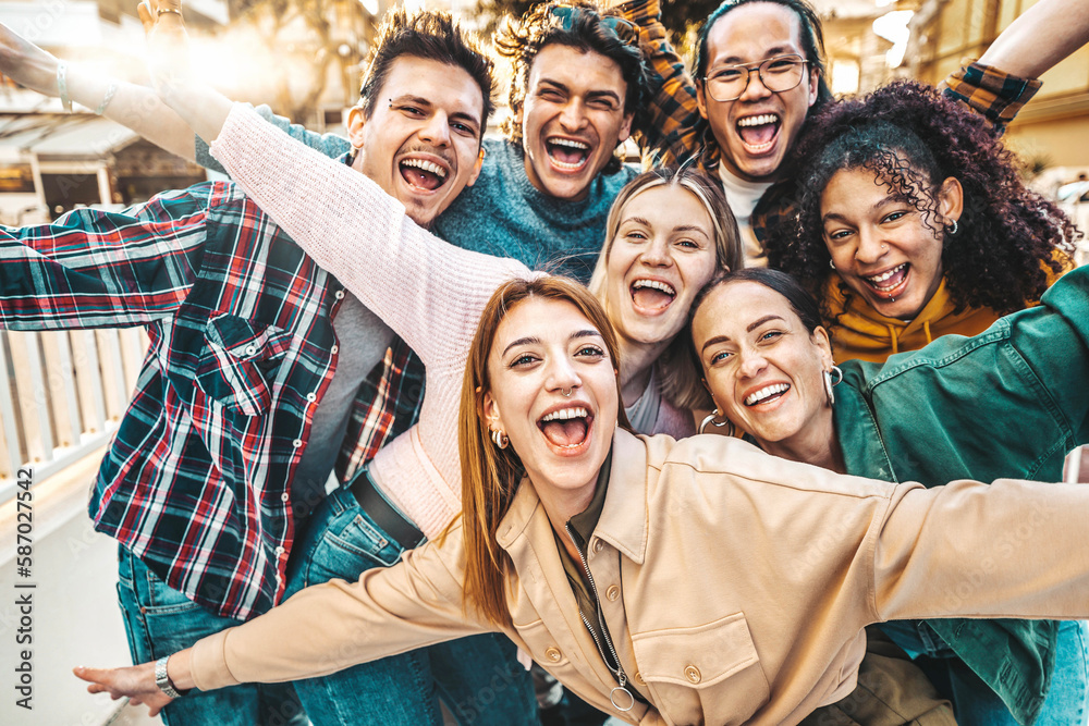 Multiracial young people smiling together at camera - Happy friends having fun hanging on city stree