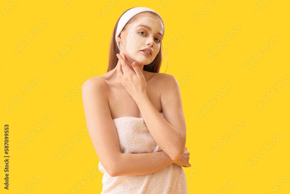 Young woman with applied turmeric mask on yellow background