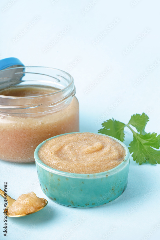 Bowl and jar with delicious caviar of capelin on blue background