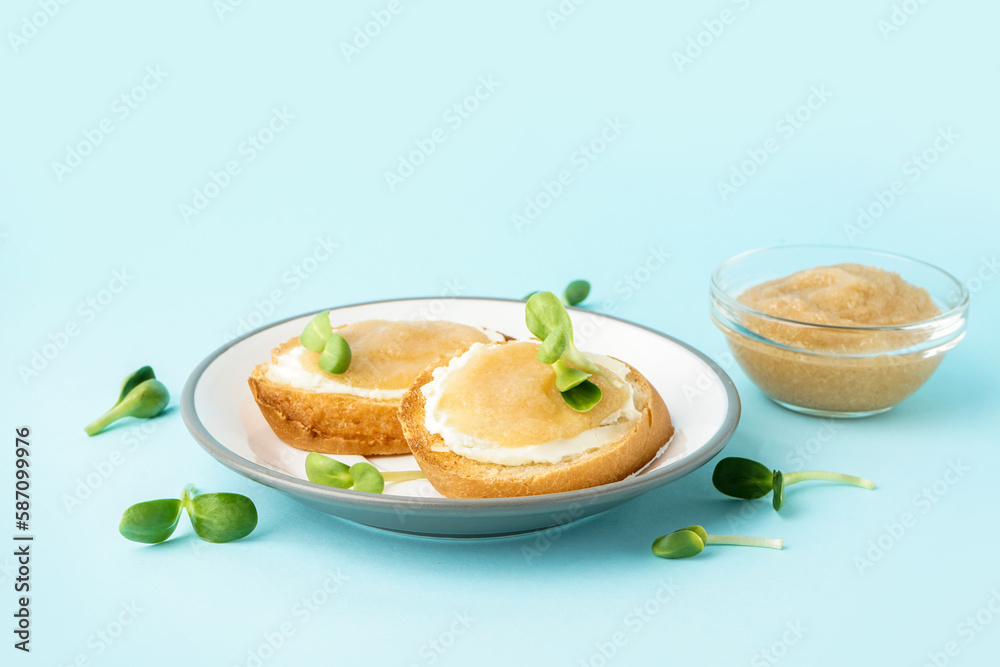 Delicious canape with caviar of capelin and microgreen on blue background