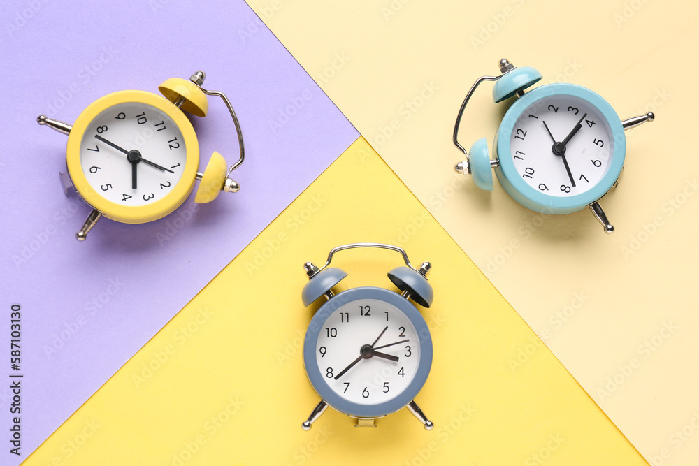 Vintage alarm clocks on color background