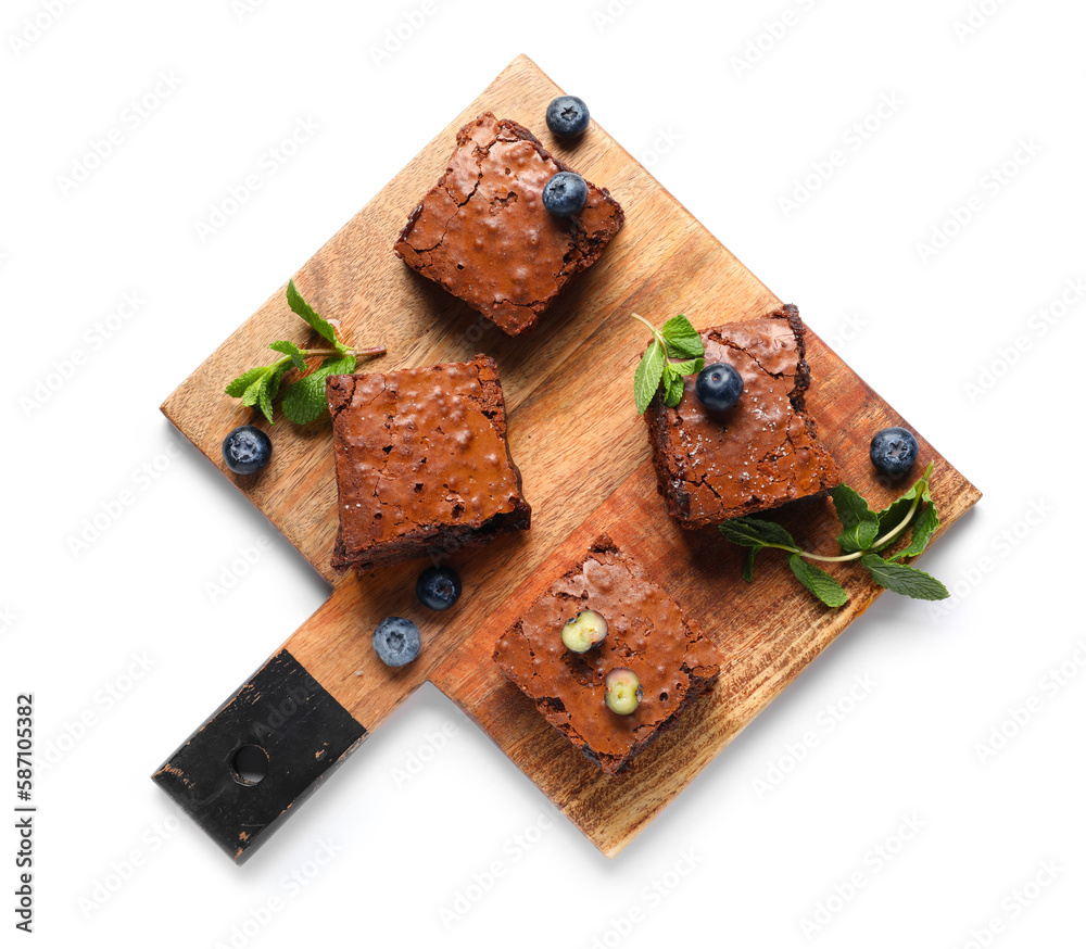 Wooden board with pieces of tasty chocolate brownie isolated on white background