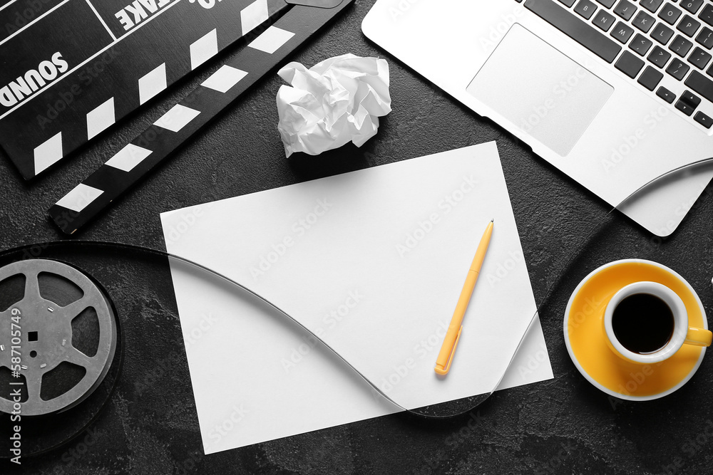 Blank paper sheet with movie clapper, film reel and cup of coffee on dark background