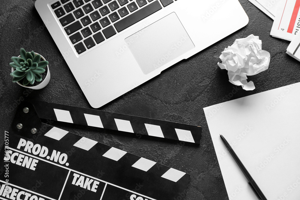 Paper sheet with movie clapper and laptop on dark background