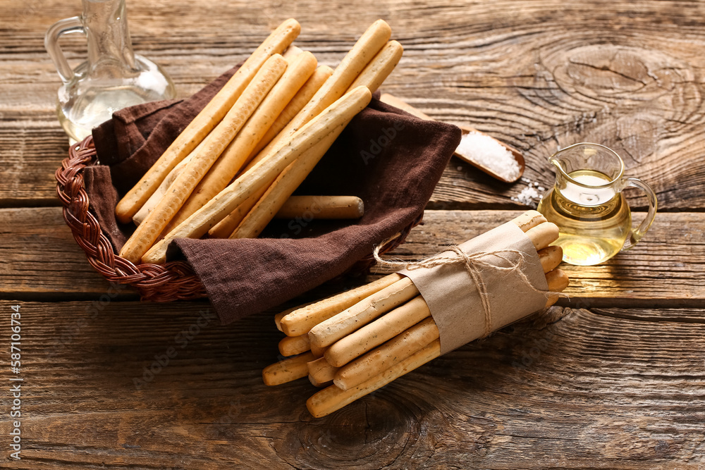 Wicker basket with tasty Italian Grissini on wooden background